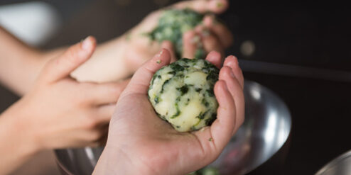 Polpettine vegane di patate e spinaci preparate da manine di bimbi